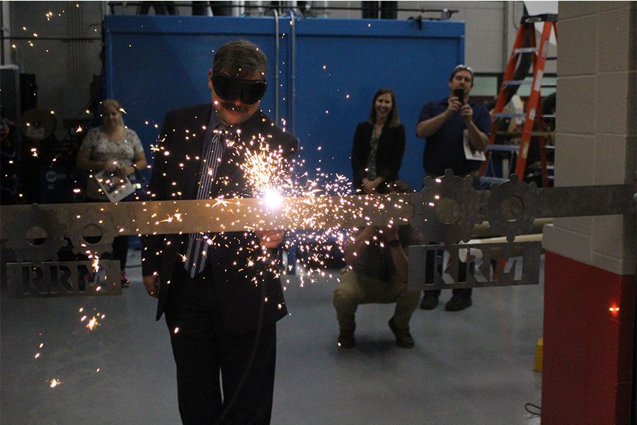 Sparks+Fly-Superintendent+Joe+Sheehan+cuts+a+metal+ribbon+with+a+plasma+cutter+at+the+ribbon+cutting+and+opening+ceremonies+of+the+new+addition.+
