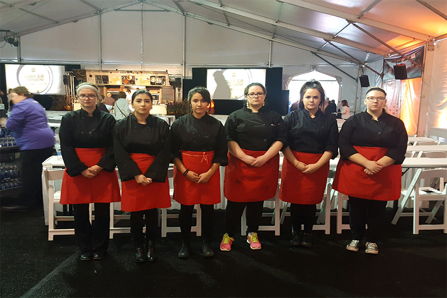 Members of the Culinary Club pose for a photo inside one of the pavilions at the Kohler Food and Wine Festival. The Food and Wine Festival draws chefs from all across the country and the world. 