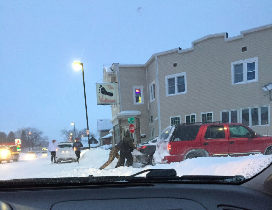 The Redwing way: Senior’s Nic Prahl and Jacob Royston can be seen helping push a car out of the snow late Monday night.