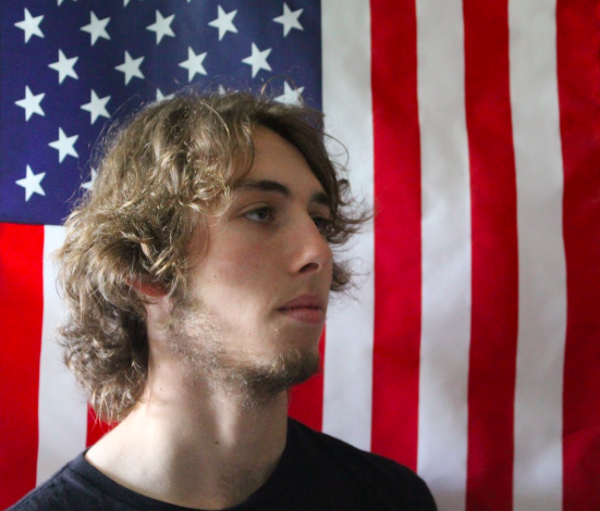 Karl Mattern in front an American flag that flies in the winds of freedom.